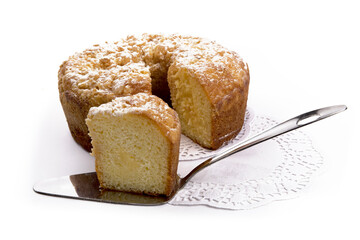 a round orange cake with a crumble top and a slice cut out isolated on white