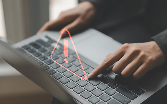 Businessman or it staff , programmer, developer using computer laptop with triangle caution warning sign for notification error and maintenance concept.