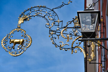 typical decorative wrought iron sign of a bull against the background of a blue sky. Isny, Germany.