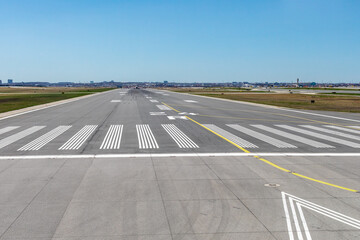 Looking down at airport runway 24 from inside an airplane about to take off on a clear day showing...