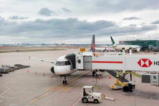 Mississauga, Canada, April 14, 2022; An Air Canada jetliner parked at the jetway ramp to load passengers with a Pakistan International Airlines Boeing 777 airplane in the background