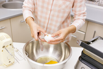 Young girl is cooking breakfast in the kitchen