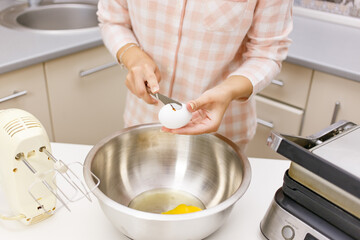 Young girl is cooking breakfast in the kitchen
