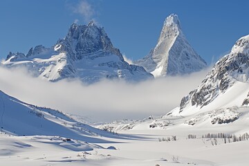 A mountain range is covered in a thick blanket of snow, with low-hanging clouds obscuring its peaks and valleys