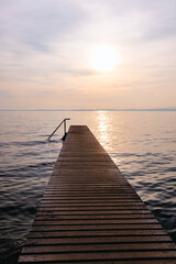 Obraz premium Wooden pier at sunset seen from walkway at Cisano, Bardolino, Lake Garda, Italy