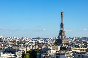 Naklejka premium Panoramic view of the Eiffel tower, on the Parisian buildings in the center, Arc de Triomphe de l'Étoile, located on the Charles de Gaulle square, and at the western end of the Champs Elysées avenue 