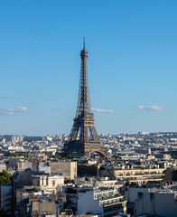 Fototapeta premium Panoramic view of the Eiffel tower, on the Parisian buildings in the center, Arc de Triomphe de l'Étoile, located on the Charles de Gaulle square, and at the western end of the Champs Elysées avenue 