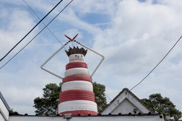 man with crown created from red and white tyres on a rooftop