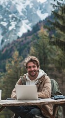 Fototapeta premium Happy male freelancer working on laptop in mountain wilderness