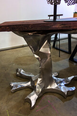Decorative silver metal coffee table leg in the shape of a tree root.