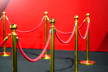 Rope fencing with gold pillars with a red carpet for celebrities and guests of an expensive event...