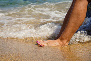 A woman feet in the ocean water.