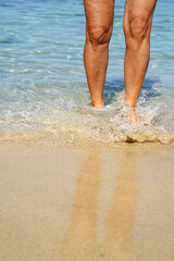 A sensual female legs in the water in summer holidays. Beauty and depilation in summertime