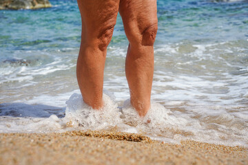 female legs on the beach shore. Summer and vacation