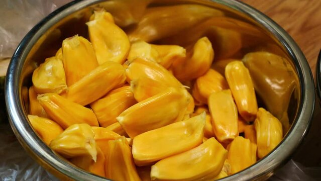 A man is manually peeling a jackfruit