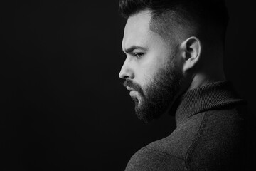 Portrait of handsome bearded man on dark background, space for text. Black and white effect