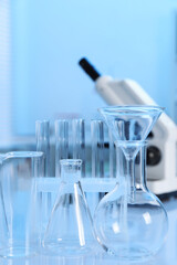 Laboratory analysis. Different glassware and microscope on white table indoors