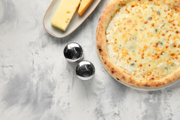Delicious cheese pizza and different kinds of cheese on light grey textured table, flat lay. Space...
