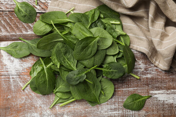 Pile of fresh spinach leaves on wooden rustic table, top view