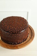 Delicious chocolate truffle cake on light wooden table