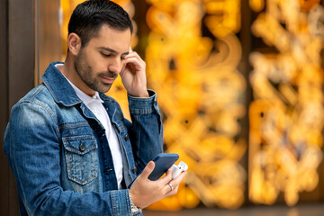 Cosmopolitan handsome man using mobile device and headphones