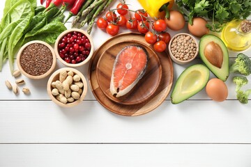 Many different healthy food on white wooden table, flat lay. Space for text