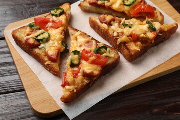 Tasty pizza toasts served on wooden table, closeup