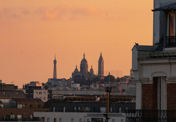 Fototapeta na wymiar sunset over the rooftops of paris with views of the Eiffel Tower, The Sacré-Cœur is a basilica on top of Montmartre hill , Paris, France