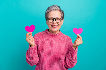 Photo of cheerful pleasant woman wear pink sweater in glasses holding two paper hearts on valentine...