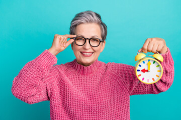 Portrait of clever cheerful person wear knit pullover fingers touch eyewear demonstrate clock isolated on turquoise color background