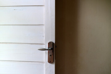 a white wooden door with white walls. with door handles made of aluminum