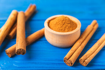 Ceylon cinnamon.Cinnamon sticks on a textured wooden background. Cinnamon roll and powder. Spicy spice for baking, desserts and drinks. Fragrant ground cinnamon. Close-up. Place for text. copy space