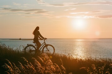 Obraz premium Summer sunset view of woman bike along the beach coast 