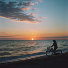 Fototapeta premium Summer sunset view of woman bike along the beach coast 