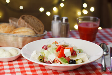 Restaurant vegetable salad with white cheese served with bread, tomato juice
