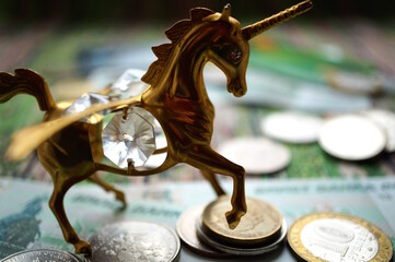 A unicorn statuette with coins on the table.
