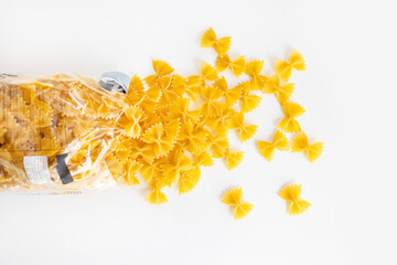 farfalle pasta in plastic bag on white background, close up, top view. Italian food.
