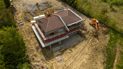 Aerial view of a villa under construction in the countryside. Construction work has stopped and...