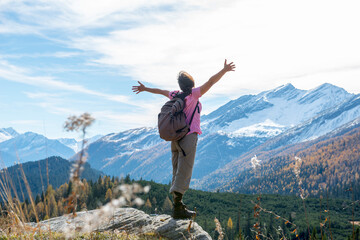 Woman Hiking and with Her Arms Outstretched and Enjoy Mountain Scape with Snow in San Bernardino, Grisons, Switzerland.