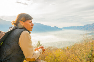 Woman Enjoy Panoramic View over Mountain Scape with a Foggy Valley in Locarno, Ticino, Switzerland.