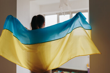 Symbolic Representation Woman's Rear View Holding Ukrainian Flag