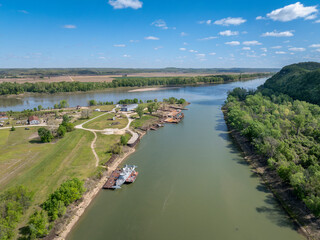 Gasconade River at confluence with the Missouri River, springtime aerial view with an old boatyard and barges