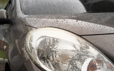 
Car in parking with
water drop rainy, foggy autumn day. Focus on car Headlight.
Concept of safety driving problem.