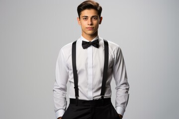 Fototapeta premium Young man in formal attire with suspenders and bow tie