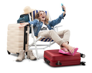 Happy joyful tourist woman in travel attire, on deck chair with trolley suitcases, make selfie with mobile phone. Summer beach holiday, flight and vacation travel booking. Travel influencer lifestyle