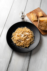 Piatto di tipici spaghetti cacio e pepe, ricetta tradizionale di pasta con pecorino e pepe nero...