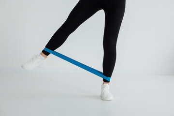 The person is wearing a blue resistance band on their leg, which is a common equipment used in...
