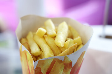 closeup of a delicious bag with potato chips. Tasty, yellow-colored street food snack.