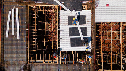 Men from the construction industry, working on the work of a building under construction. Placing...