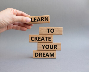 Dreams symbol. Concept words Learn to create your Dreams on wooden blocks. Beautiful grey background. Businessman hand. Business and Learn to create your Dreams concept. Copy space.
